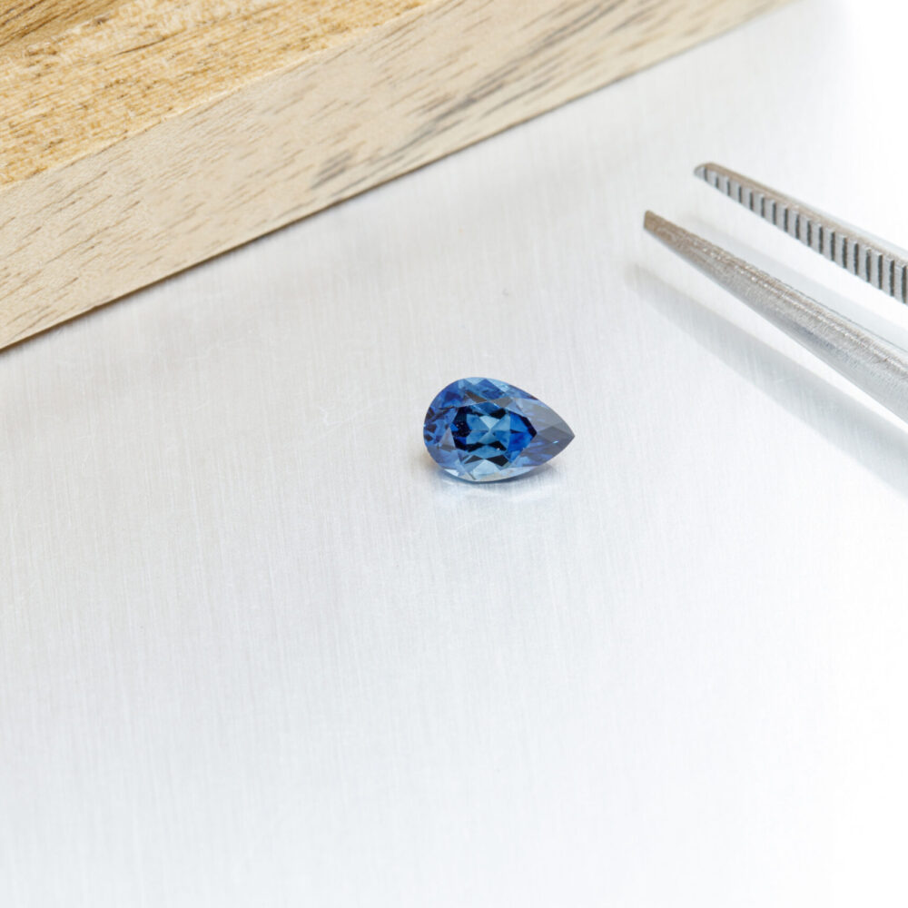 macro mineral faceted stone Sapphire on a gray background close-up